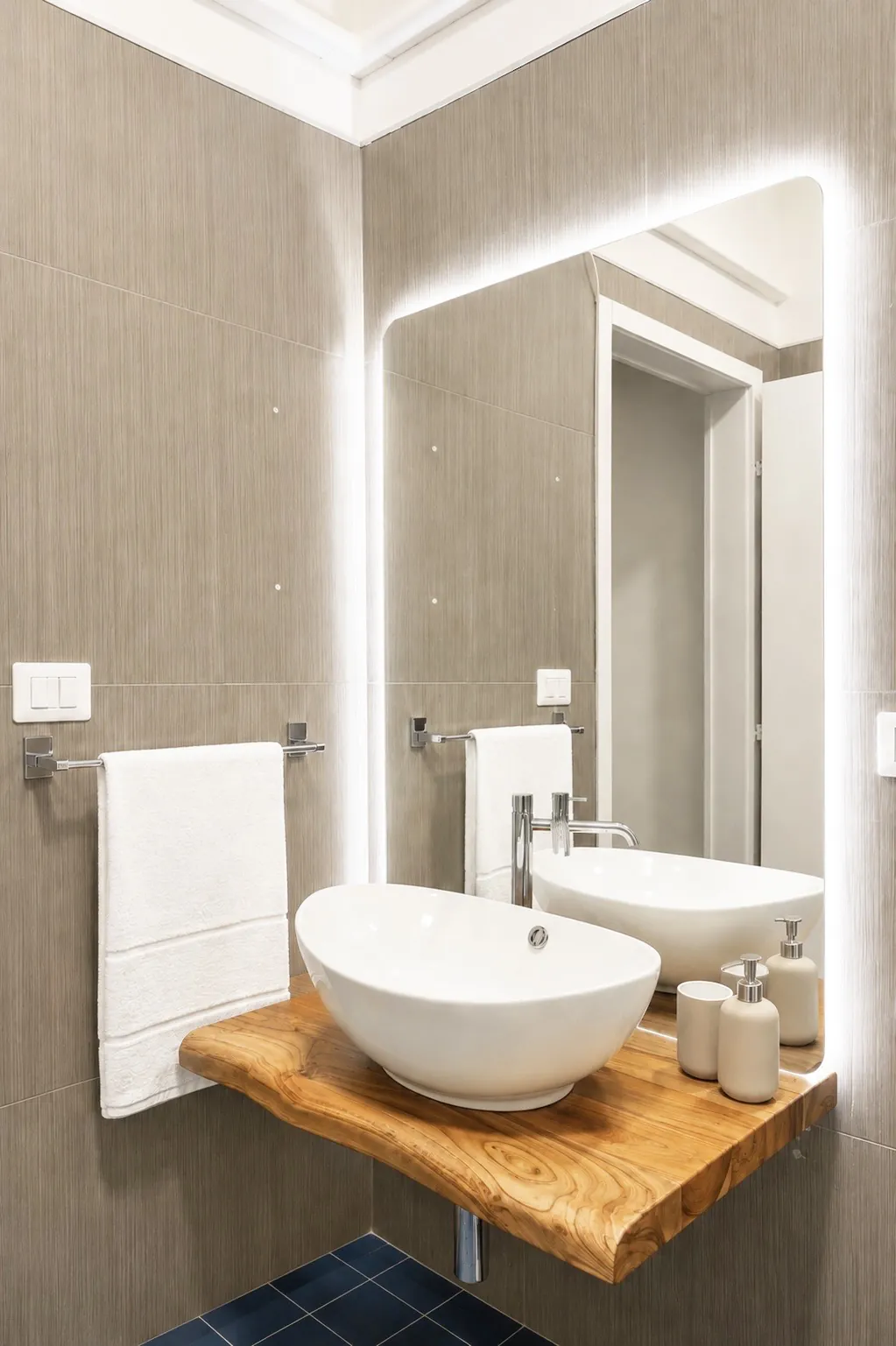 Lavabo bianco su mensola di legno grezzo con specchio illuminato