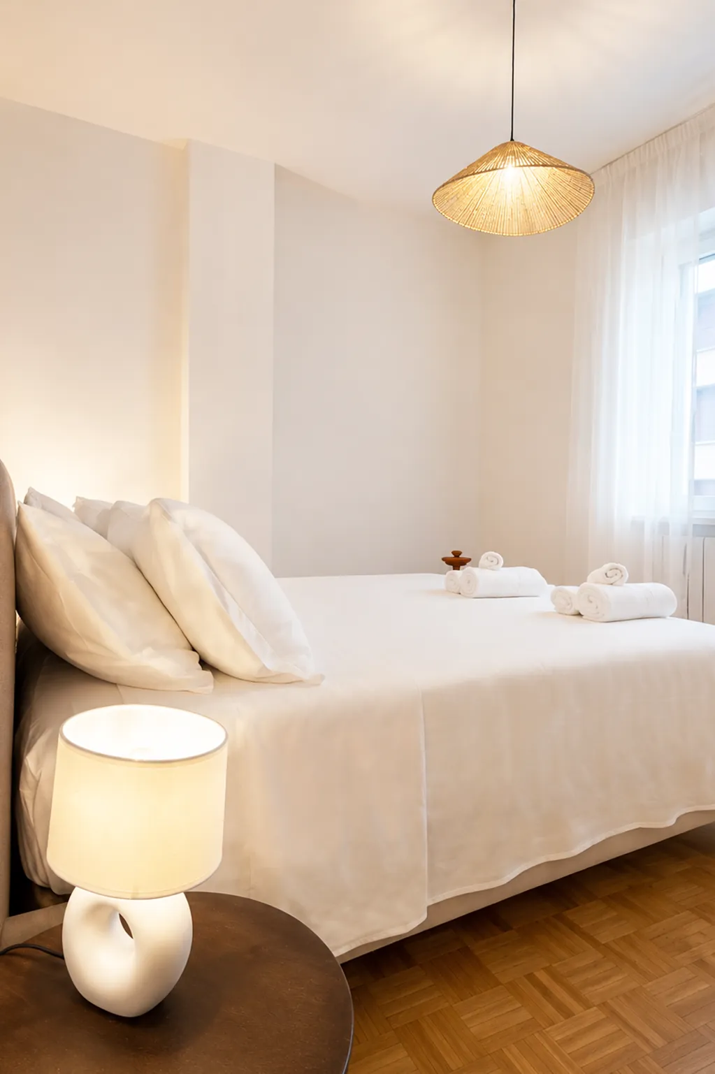 Comodino di legno con lampada bianca accanto al letto